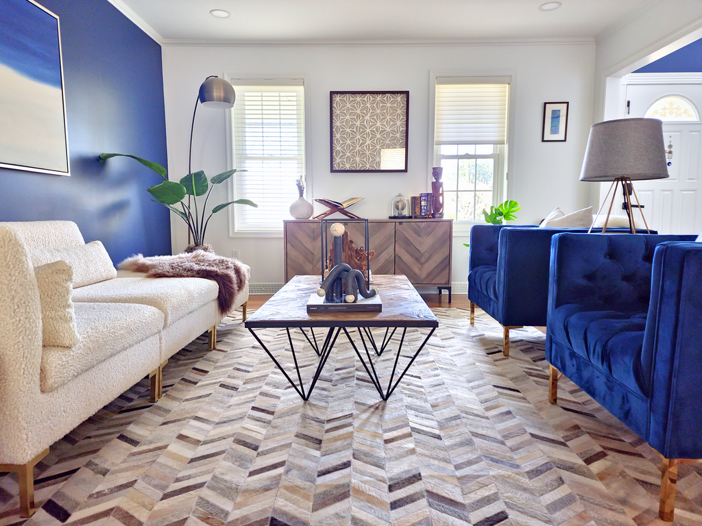 a living room with blue walls and a chevron rug