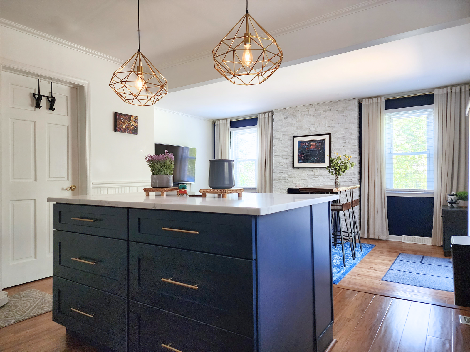 blue and beige kitchen with gold and matte black accents and a beautiful wood grain floors design by bespoke by ali fasi main line philadelpha
