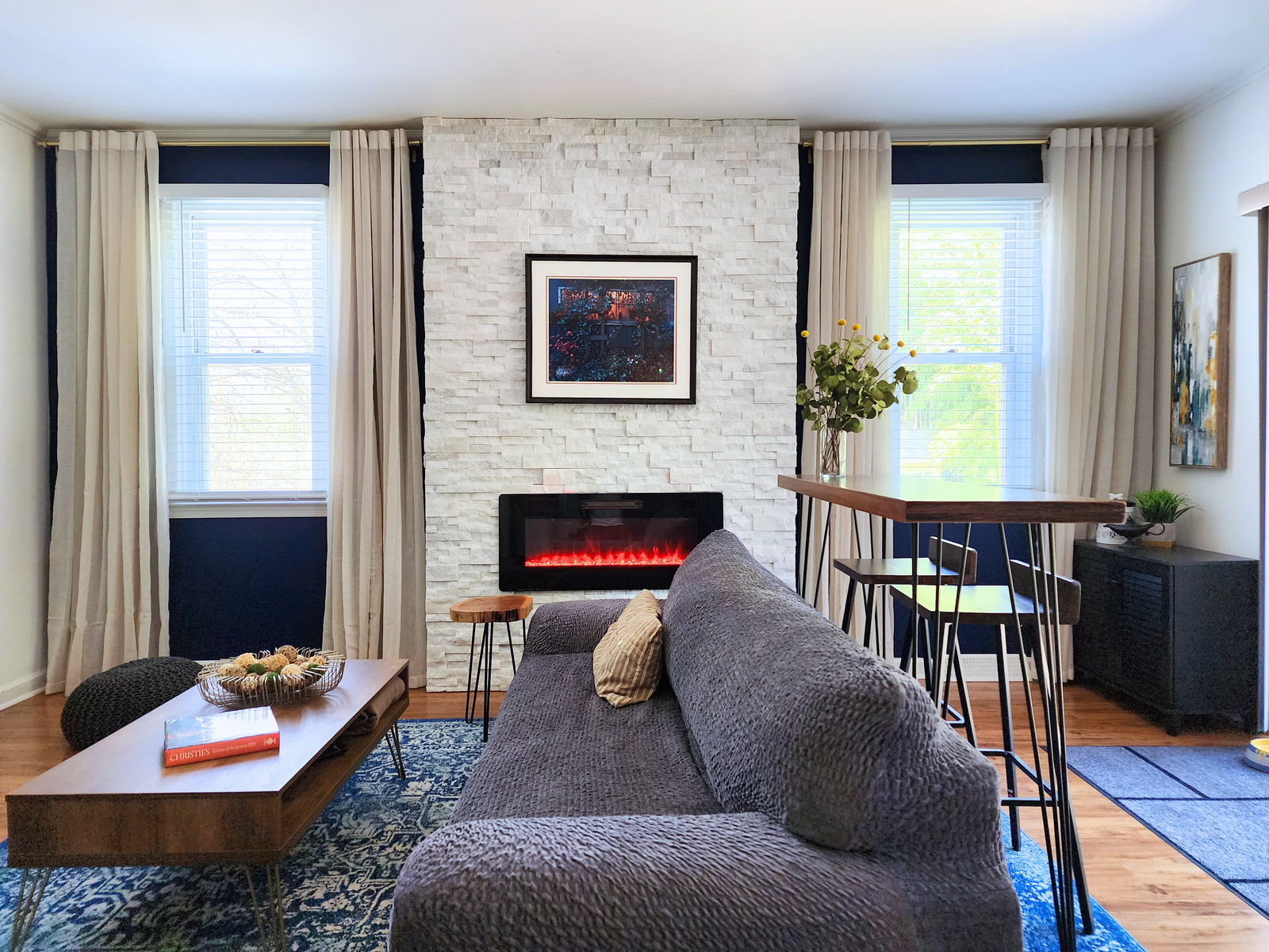 a living room with blue walls and a fireplace design by bespoke by ali fasi main line philadelpha